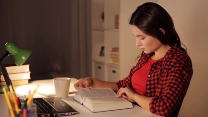 Wall Mural - student girl or woman reading book at night home