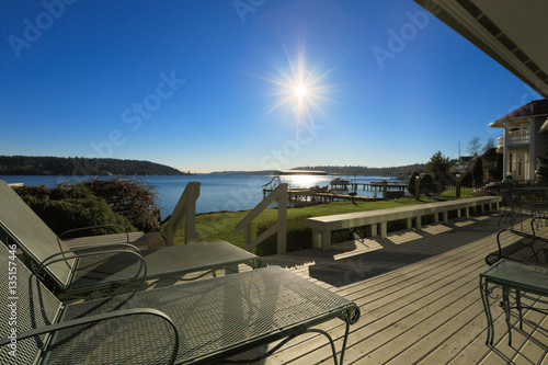 Fotografía Large spacious deck of grey waterfront home at sunset
