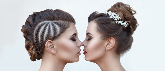 Two beautiful young women with high-quality make-up, close-up face on a light background with a professional haircut