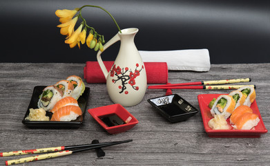 Sushi rolls set served for two on black and red tables on wooden table