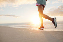 Feet Of Young Woman Jogging On The Beach