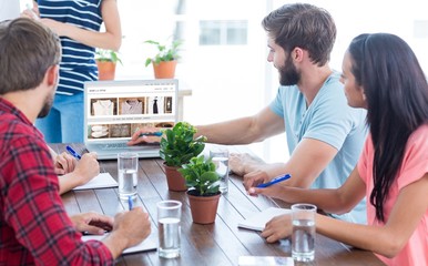 Poster - Composite image of business team using a laptop 