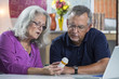 © Burlingham - A senior aged couple reading the label on a prescription bottle