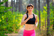 © Maksym Protsenko - Young Woman Running on the Trail in the Beautiful Wild Forest. Active Lifestyle Concept. Space for Text.