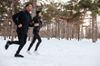 © Drobot Dean - Young fitness couple running in the forest in winter