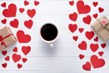 Wall Mural - A cup of coffee on the white wooden table with hearts and gifts boxs. Romantic background to Valentine's Day, Dating, couples in love. Flat lay.