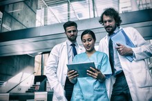 Doctors And Nurse Looking At Digital Tablet
