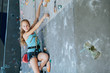 One teenager climbing a rock wall indoor.