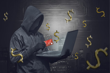 Poster - Hooded man wearing anonymous mask and holding laptop while showing credit card