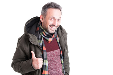 Wall Mural - Male posing wearing winter jacket showing thumb up gesture