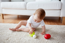 Happy Baby Playing With Balls On Floor At Home