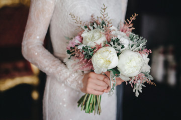 wedding bouquet with white and pink flowers in the bride's hands