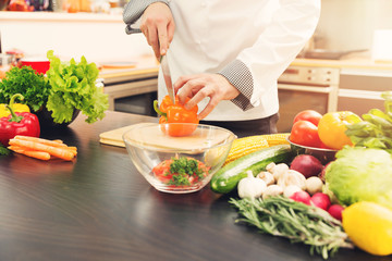 chef cutting paprika for vegetable salad in kitchen