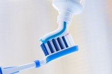 Closeup Of A Toothbrush And Toothpaste On Blurred Background