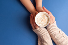 Two Pairs Of Hands Holding Coffee With Milk Froth And Cinnamon On Top