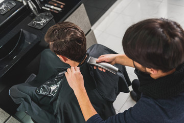 Wall Mural - Professional barber undergoing hairdo by clipper