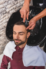 Wall Mural - Happy guy getting hairwash at beauty salon