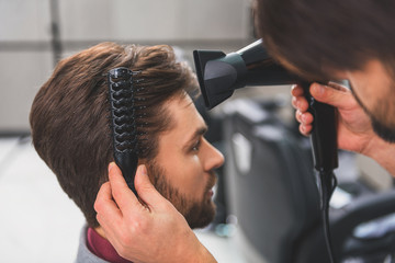 Wall Mural - Barber using hairdryer at beauty salon