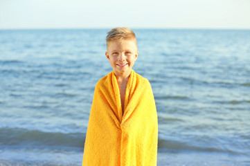 Canvas Print - Cute boy wrapped in towel on beach