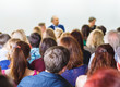 © Feel good studio - Students listening the professor's lecture, sitting rear in conference room. Education concept.
