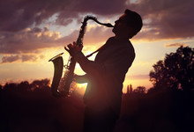 Saxophonist Playing Sax Against Sunset