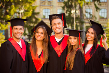 Canvas Print - successful joyful five graduates in robes and hats with tassel s