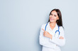 © deagreez - Friendly smiling young female doctor pointing with finger