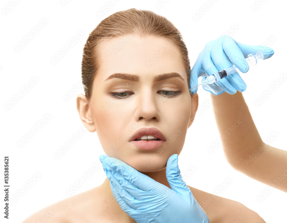 Young woman having cosmetic injection on white background. Plastic surgery concept