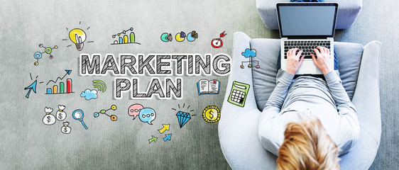 Wall Mural - marketing plan text with man using a laptop