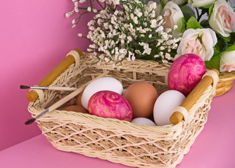  пасхальные яйца в корзинке на розовом фоне 