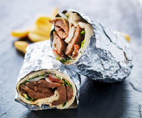 Sticker - greek gyro wrapped in foil cut in half and served with fries