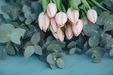 Wall Mural - Flower decoration. Fresh pink tulip flowers bouquet on eucalyptus leaves.