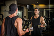 © theartofphoto - Handsome muscular young man exercising biceps in gym with dumbbells