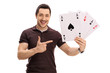 Happy guy holding four aces and pointing