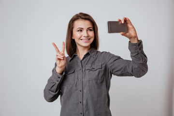 Sticker - Cheeful young lady make selfie by mobile phone.