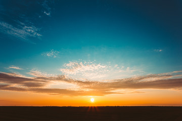 Wall Mural - Sunset Sunrise Over Field Or Meadow. Bright Dramatic Sky And Dar