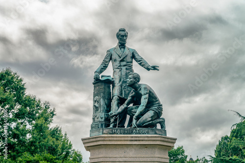 The bronze statue features President Lincoln standing with his left arm out-stretched over a crouching freed slave Tableau sur Toile