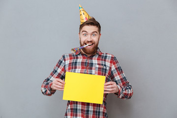 Wall Mural - Happy young bearded birthday man holding copyspace board