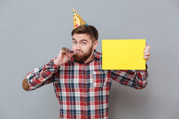 Wall Mural - Cheerful young bearded birthday man holding copyspace board