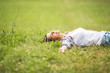 © BalanceFormCreative - Young woman lying down on grass.She enjoys in the moment of peace.