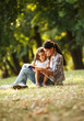 © BalanceFormCreative - Mother and daughter relaxing in park.She reading a fairytale to her daughter