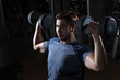 © stnazkul - Man lift weight on shoulder press with studio light shot