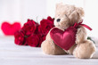 Cute valentine’s teddy bear with red roses, love concept