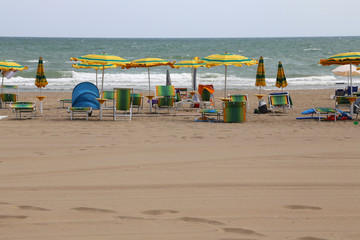 Wall Mural - rough sea and the beach with many umbrellas