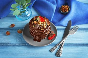 Sticker - Plate with delicious chocolate pancakes decorated with strawberry and nuts on wooden table