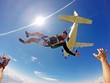 Funny parachutist jumps from an airplane on a summer day. Point of view