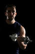 © Africa Studio - Sporty man doing exercises with dumbbell on black background