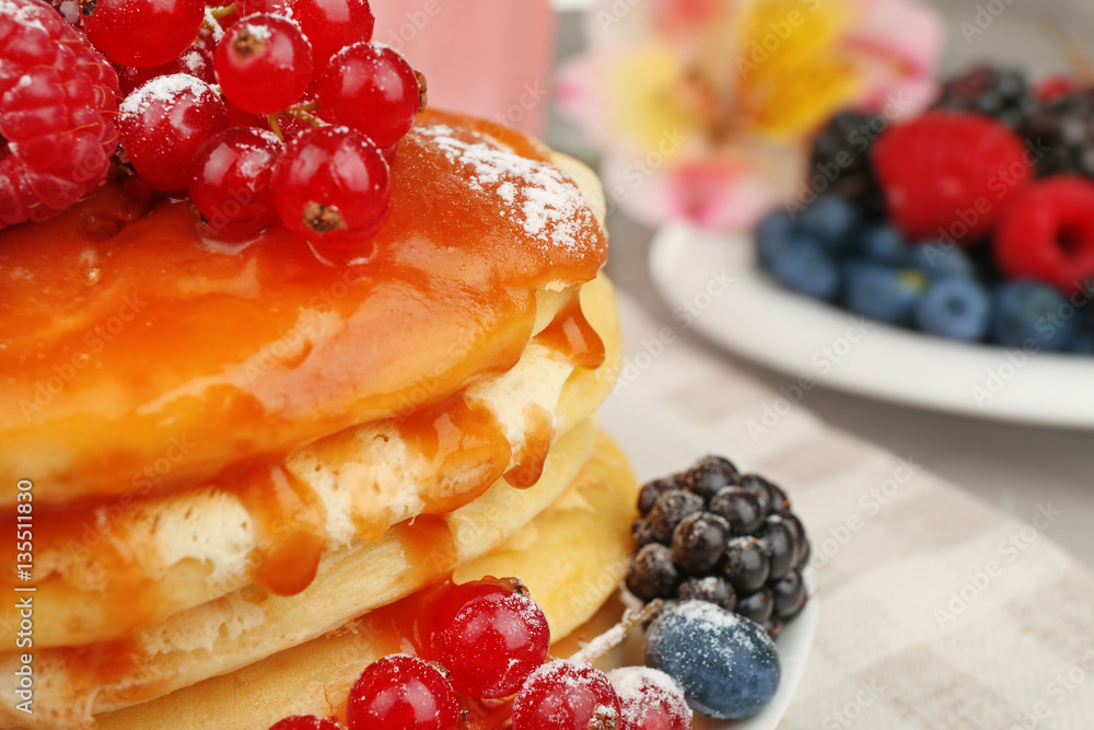 Delicious pancakes with berries and sweet syrup, closeup