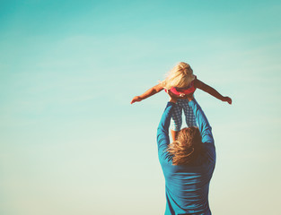 Father and little daughter play at sky