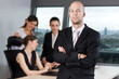 © Adam Gregor - manager in front of his business team in a panorama office